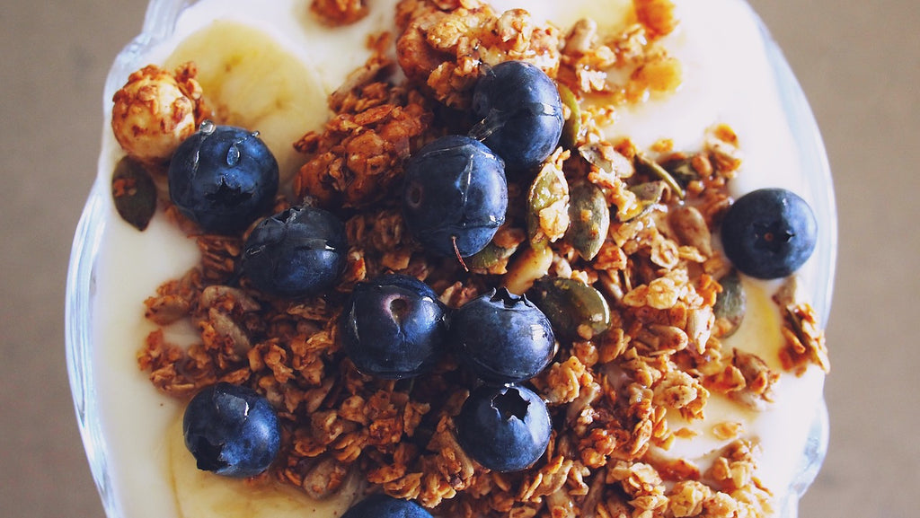 Oats and granola over yogurt with bananas and blueberries